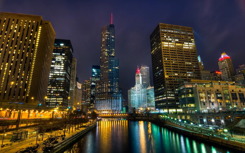 Trump Tower and the Chicago River at night, lights reflecting on the water